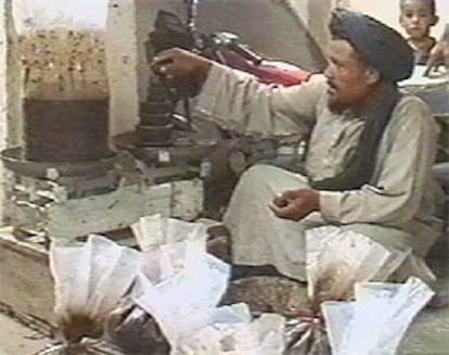 Un traficante afgano pesa su opio en el mercado de Sangin (Afganistán).