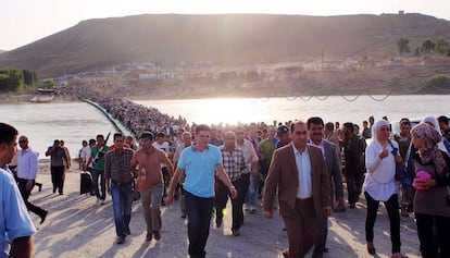 Miles de sirios cruzan un puente sobre el río Tigris de camino a la región autónoma del Kurdistán iraquí.