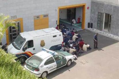 Un grupo de inmigrantes espera junto al edificio de los juzgados de Arona (Tenerife).