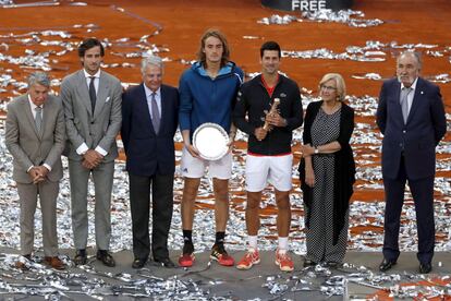 El tenista serbio Novak Djokovic y el griego Stefanos Tsitsipas tras la final del Mutua Madrid Open, posan junto con Manuel Santana (primero por la izquierda), Feliciano López (segundo por la izquierda), Ignacio Garralda (tercero por la izquierda), Manuela Carmena (segunda por la derecha) e Ion Tiriac (primero por la derecha).