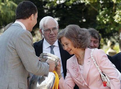 El Príncipe Felipe le enseña la copa a la Reina Sofía, para que compruebe que todavía huela a champán.