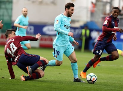 El delantero argentino del Barcelona, Lionel Messi (c), supera la defensa de los centrocampistas del Eibar, Daniel García Carrillo (i) y el francés Pape Diop (d).