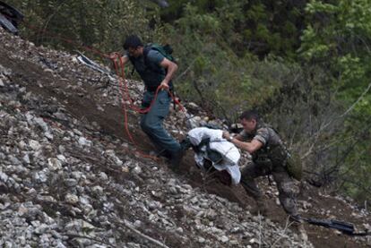 Dos militares españoles trasladan uno de los cadáveres.