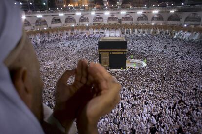 Un devoto musulmán reza durante la Laylat al-Qadr, la Noche del Decreto, en el día 27 del Ramadán, mientras una multitud de peregrinos rodea la  Kaaba en La Meca (Arabia Saudí).