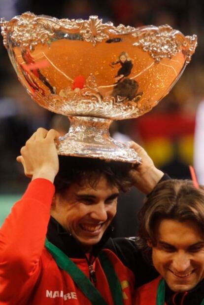 Rafa Nadal holds the trophy on top of his head during the celebrations.