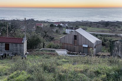 El color gris de la madera y la escala integran la casa en su entorno rural.