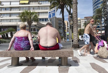 Dos personas con sobrepeso, en un banco de Benidorm.