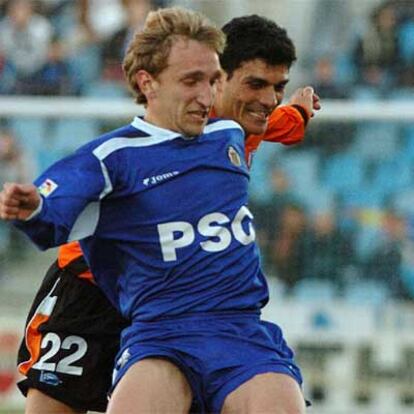 Diego Rivas (dcha), del Getafe, intenta controlar el balón ante el empuje de Aloisi, del Alavés.