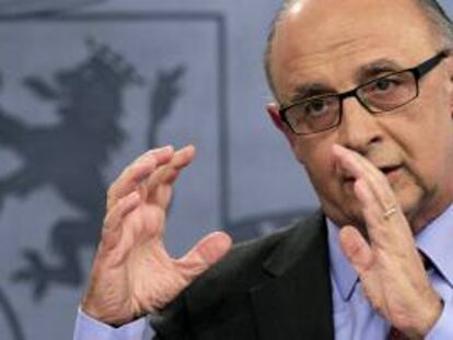 El ministro de Hacienda y Administraciones Públicas, Cristóbal Montoro, durante la rueda de que prensa que ofreció junto al titular de Economía, Luis de Guindos, y la vicepresidenta del Gobierno, Soraya Sáenz de Santamaría, al término de la reunión del Consejo de Ministros en la que se aprobó el proyecto de Presupuestos Generales del Estado para 2013.