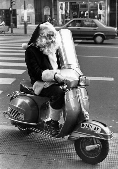 Un Papa Noel en Vespa en la Gran Vía, el 11 de diciembre de 1990. El debate sobre el tráfico en el centro de Madrid viene de largo. A principios de diciembre de 1990, el anuncio de restricciones a la circulación en el centro de la capital del concejal de Circulación y Transportes del Ayuntamiento de Madrid, Eduardo Larraz, chocó con la opinión de otros miembros de la corporación municipal. El coste político de tomar tal decisión pesó más que los consejos de los técnicos municipales para evitar los monumentales atascos navideños de años anteriores. Al final la cosa quedó en una prohibición de aparcar (medida que ya se aplicaba desde 1979) y limitaciones al tráfico privado en una pequeña zona alrededor de Callao y la calle de Atocha.