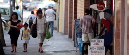 Una familia pasa por delante de la tienda donde fue secuestrada la segunda niña.