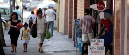 Una familia pasa por delante de la tienda donde fue secuestrada la segunda ni&ntilde;a.