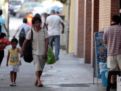 Una familia pasa por delante de la tienda donde fue secuestrada la segunda ni&ntilde;a.