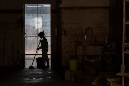 Un niño limpia el suelo de los bajos de una vivienda en la calle San Eusebio, una de las más afectadas por la riada, el 14 de noviembre. En la entrada de la casa, un piano de cola, apoyado con cuidado, destaca como símbolo de la devastación. Javier, su propietario, relata cómo el barro destruyó la sala de música en los bajos de su hogar, diseñada especialmente para que el piano resonara a la perfección. Mientras conversábamos con él, al fondo, un niño pasaba una fregona, deslizándola con esfuerzo, el mango superando su altura. La escena evocaba la música imaginaria del piano, acompañando los movimientos del niño mientras intentaba borrar los rastros de la dana del 29 de octubre. 