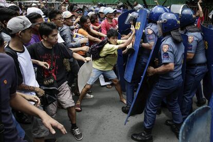 Varios activistas se enfrentan a la policía antidisturbios durante una manifestación contra la declaración de la ley marcial en el Tribunal Supremo, en Manila (Filipinas).