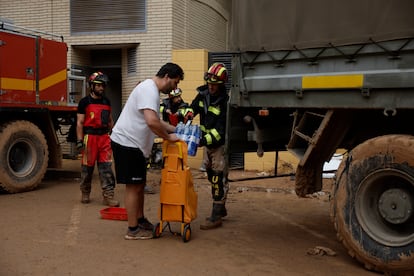 Efectivos de la Unidad Militar de Emergencias reparten agua a los vecinos de Paiporta, este viernes.