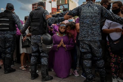 Una mujer se arrodilla mientras espera la procesión del Nazareno de San Pablo, la principal advocación de Jesucristo en Venezuela, este miércoles, en Caracas.