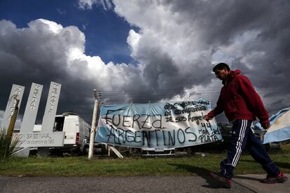 Un hombre camina frente a una bandera argentina con mensajes de apoyo a los desaparecidos frente a la Base Naval de Mar de Plata, el 20 de noviembre de 2017.