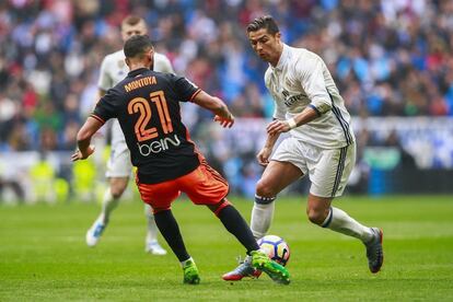 Cristiano Ronaldo (d), del Real Madrid, regatea a Santi Mina del Valencia.