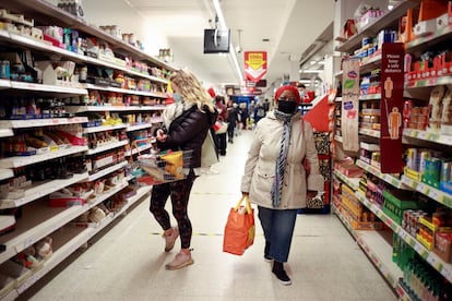 Varias personas compran en un supermercado de Londres.