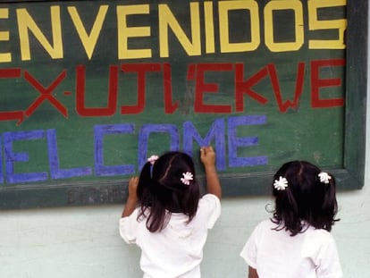 Dos niñas alumnas de la Institución Educativa Toribío escriben un cartel de bienvenida a su escuela.