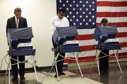 President Barack Obama, left, casts his vote during early voting in the 2012 election Thursday, Oct. 25, 2012, in Chicago, at the Martin Luther King Community Center. (AP Photo/Pablo Martinez Monsivais)