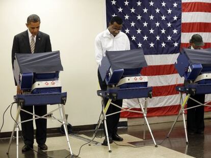 President Barack Obama, left, casts his vote during early voting in the 2012 election Thursday, Oct. 25, 2012, in Chicago, at the Martin Luther King Community Center. (AP Photo/Pablo Martinez Monsivais)
