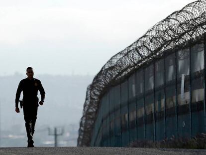 Un agente de la policía de fronteras, junto a la valla en San Diego. 