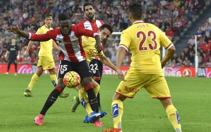 Iñaki Williams protege el balón ante dos jugadores del Sporting.