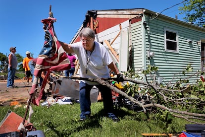 Patti Manley, de 69 años, retira una bandera estadounidense después de la violenta tormenta, en Mehlville, Misuri.