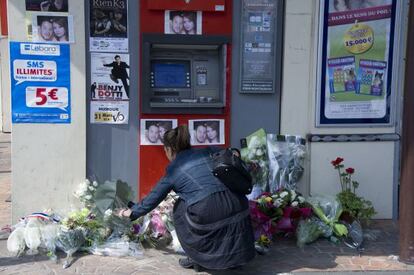 Una joven coloca un ramo de flores en el cajero en el que fueron asesinados dos soldados el pasado 15 de marzo, en Montauban.