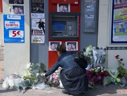 Una joven coloca un ramo de flores en el cajero en el que fueron asesinados dos soldados el pasado 15 de marzo, en Montauban.