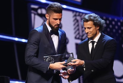 El jugador del Arsenal Olivier Giroud recibe el premio Puskas al Mejor Gol de manos del exjugador Diego Forlán.