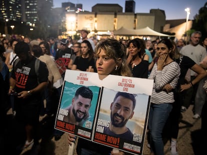 Una mujer sostiene una foto de dos rehenes que fueron secuestrados por Hamás, el martes en Tel Aviv.