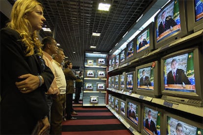 Un grupo de brasileños sigue el discurso de Lula en las pantallas de un centro comercial de São Paulo.