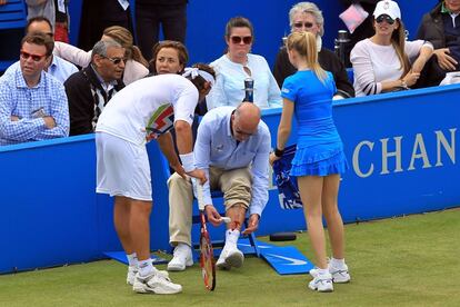 David Nalbandian (esq.) mira la sang que raja de la cama del jutge de línia per una ferida a conseqüència d'una puntada de peu que el tennista argentí va propinar a una tanca publicitària durant la final del torneig de Queen's el 2012. Nabaldian va quedar eliminat per l'acció i el croat Marin Cilic va ser el vencedor del campionat.