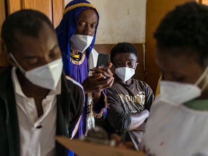 La voluntaria de la Cruz Roja sudafricana, Marrieth Ndlela, toma los datos del migrante de origen congoleño John Nsombo para apuntarlo al programa Tracing the Faces, que consiste en difundir fotos de personas que están buscando a sus seres queridos para intentar reunirlos. En Pretoria, Sudáfrica, el 18 de diciembre de 2020.