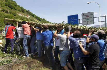 Todos a una. Los mineros, que ocultaban su rostro con pañuelos y gorras, han cargado juntos el material para las barricadas.