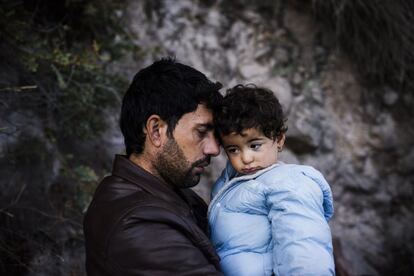 Un inmigrante con su hijo en brazos poco después de llegar a la isla griega de Lesbos tras cruzar el mar Egeo desde Turquía.
