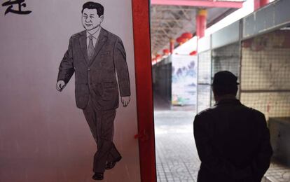 Un hombre camina junto a una imagen del presidente chino, Xi Jinping, este lunes en un mercado de Pequín.