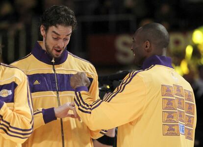 Los jugadores de los Angeles Lakers Pau Gasol, izquierda, y Kobe Bryant miran sus anillos de campeones de la NBA durante la ceremonia de entrega antes del partido de baloncesto contra los Houston Rockets en Los Angeles, el martes 26 de octubre de 2010.