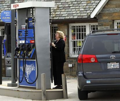 Una mujer pone gasolina en una estación de servicio en Washington D.C.