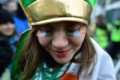 Una joven con las pestañas de la bandera de Irlanda espera el desfile de San Patricio en Dublín.