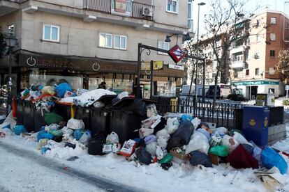 Basura apilada al lado de la boca de metro de Urgel en Madrid este lunes. El grupo socialista en el Ayuntamiento de Madrid ha pedido este lunes que la recogida domiciliaria de residuos siga suspendida al menos 48 horas más, dado que por culpa de la nevada del fin de semana "las calles siguen sin ser seguras para los camiones de este servicio, que no pueden usar cadenas". El delegado de Medio Ambiente y Movilidad de Madrid, Borja Carabante, informó el domingo de que la recogida domiciliaria de residuos, que quedó suspendida el sábado, tardaría "varios días" en ser restablecida.