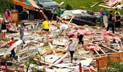 Varias personas buscan sus pertenencias tras la tormenta el sábado.