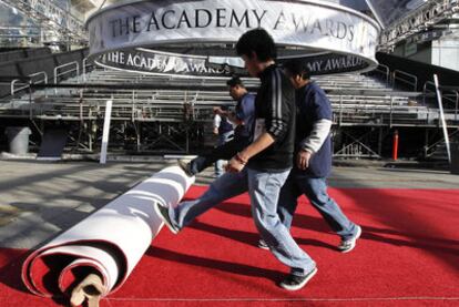 Varios operarios desenrollan la alfombra roja el miércoles en la puerta del teatro Kodak.