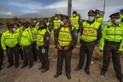 Policías prestan guardia tras una erupción de ceniza del volcán Cotopaxi.