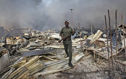 Un soldado somalí camina a través de los escombros después de que un fuego se haya propagado por el principal mercado de Mogadiscio, (Somalia).