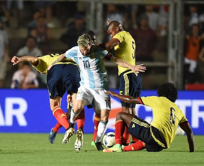 Messi consigue salvar el balón ante los jugadores de la selección colombiana, Wilmar Barrios (c) y Carlos Sanchez (d).