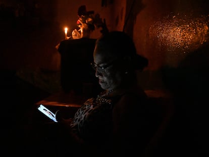 Una mujer revisa su celular en medio de un apagón en Tegucigalpa, Honduras, el 13 de junio.